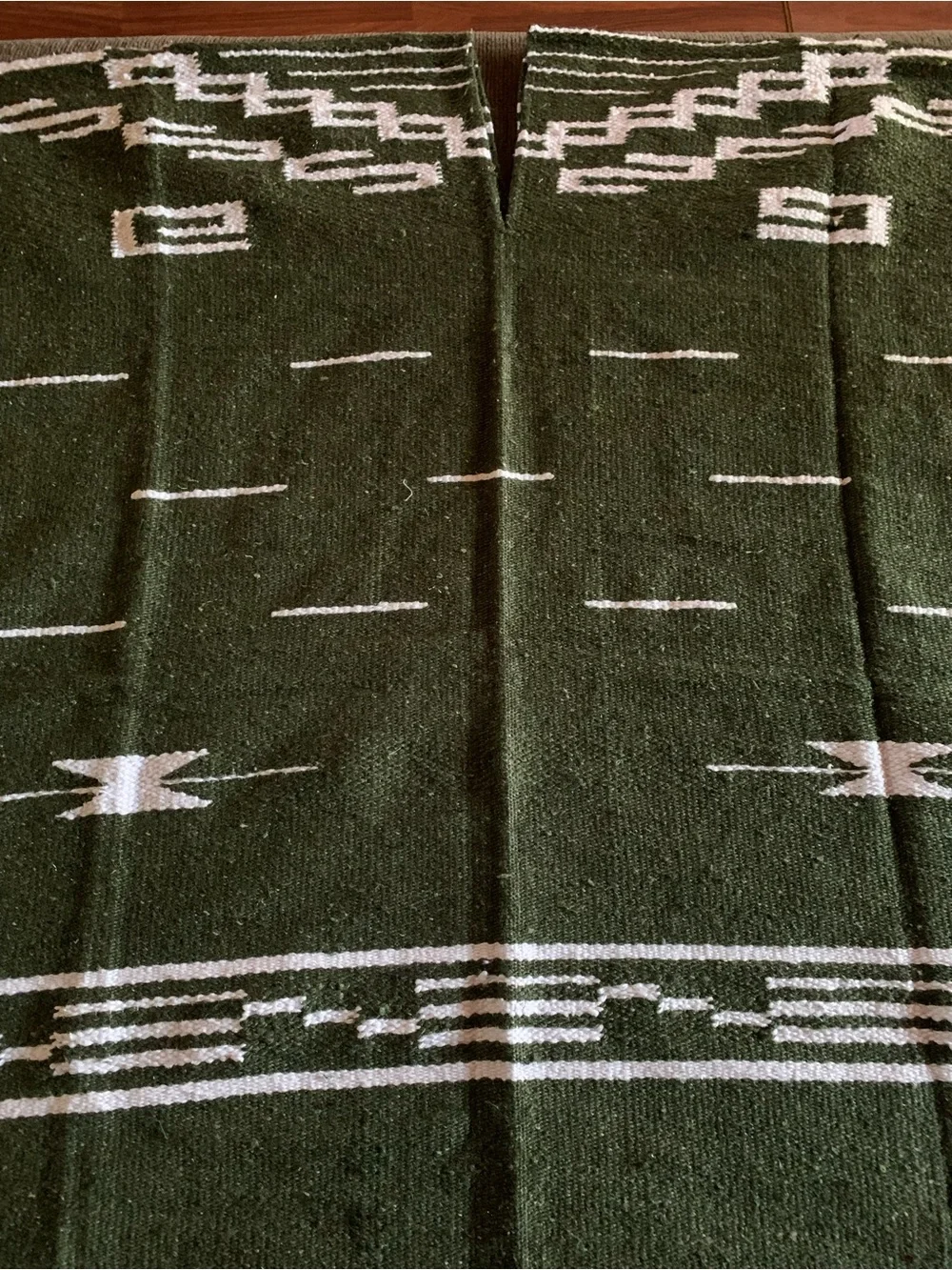 olive green Mexican-style blanket poncho featuring a geometric pattern